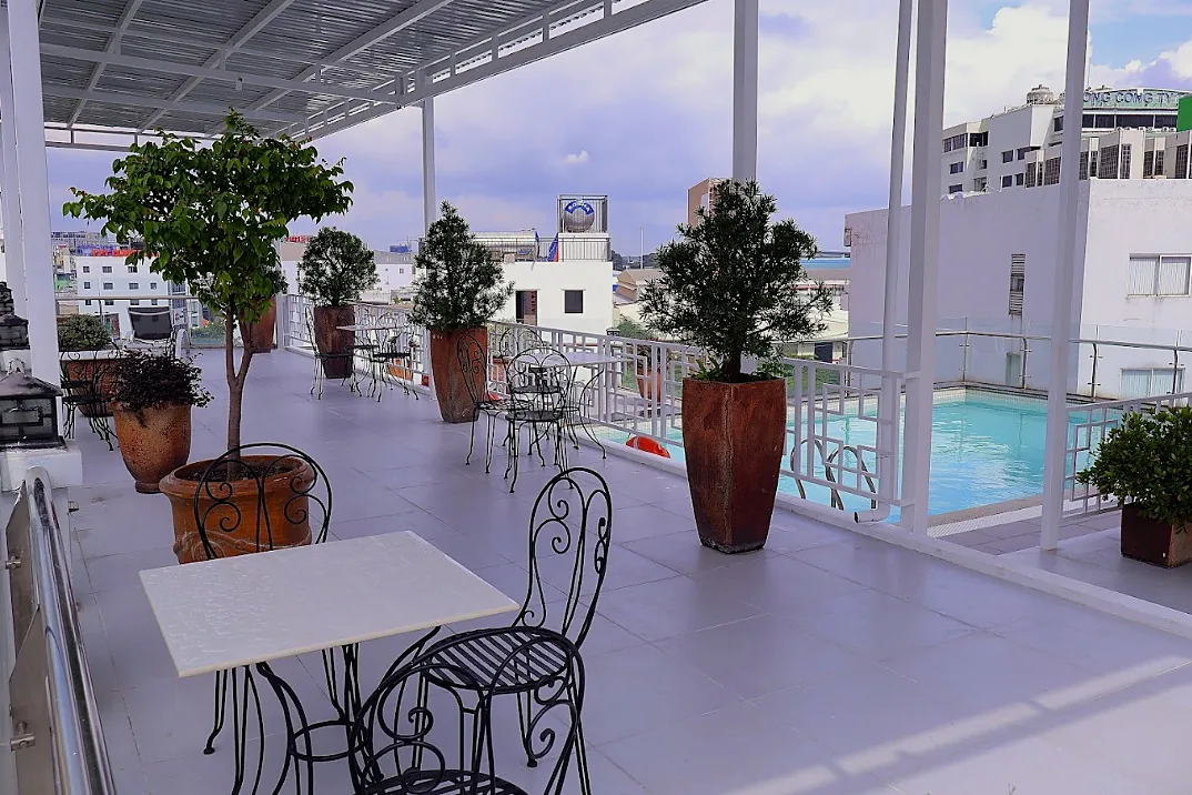 Rooftop garden with planters and iron tables around the pool